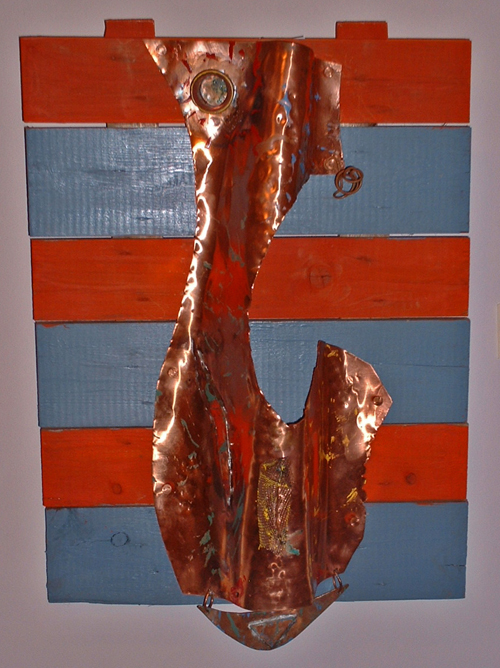 Tall hammered copper figure on red and blue wooden slats