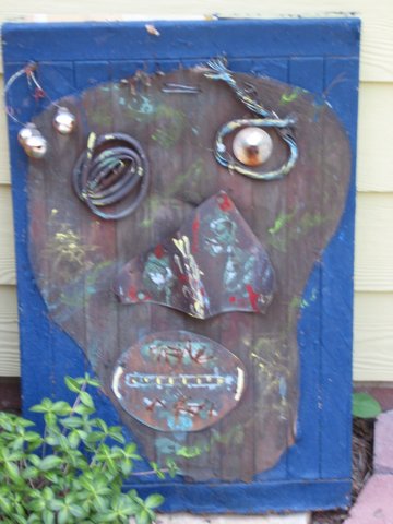 Abstract metal face assembled on a deep blue wooden panel